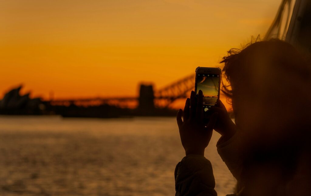 オーストラリア留学中にシドニーの夕景をスマートフォンで撮影する様子