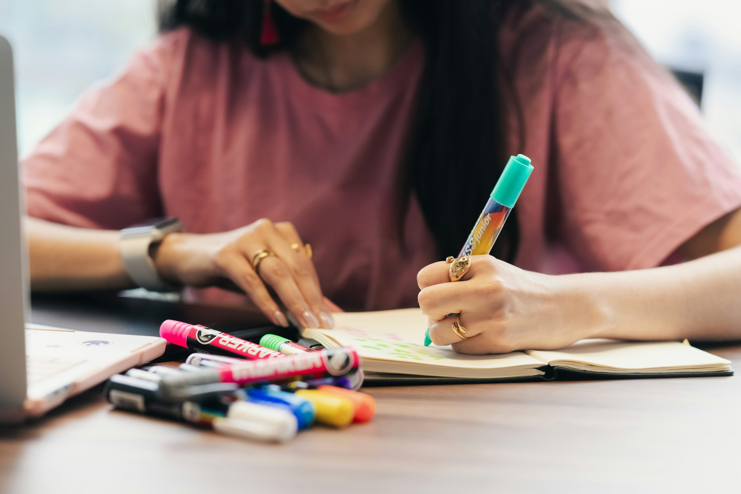 ノートに英語学習の内容を書き込む女性